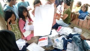 Orang tua dan anak-anak yang sedang memilih ukuran baju seragam
